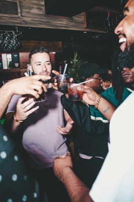 Friends toasting with cocktails at a bar